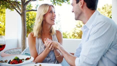 romantic couple interacting with each other in restaurant