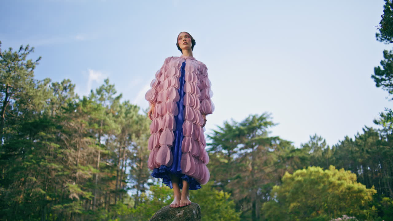 그림 같은 이 있는 숲에 서 있는 화려한 여인. 요정 소녀가 포즈를 취하고 있다.