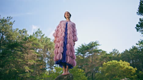 gorgeous woman standing stone at picturesque sunny forest. fairy girl posing