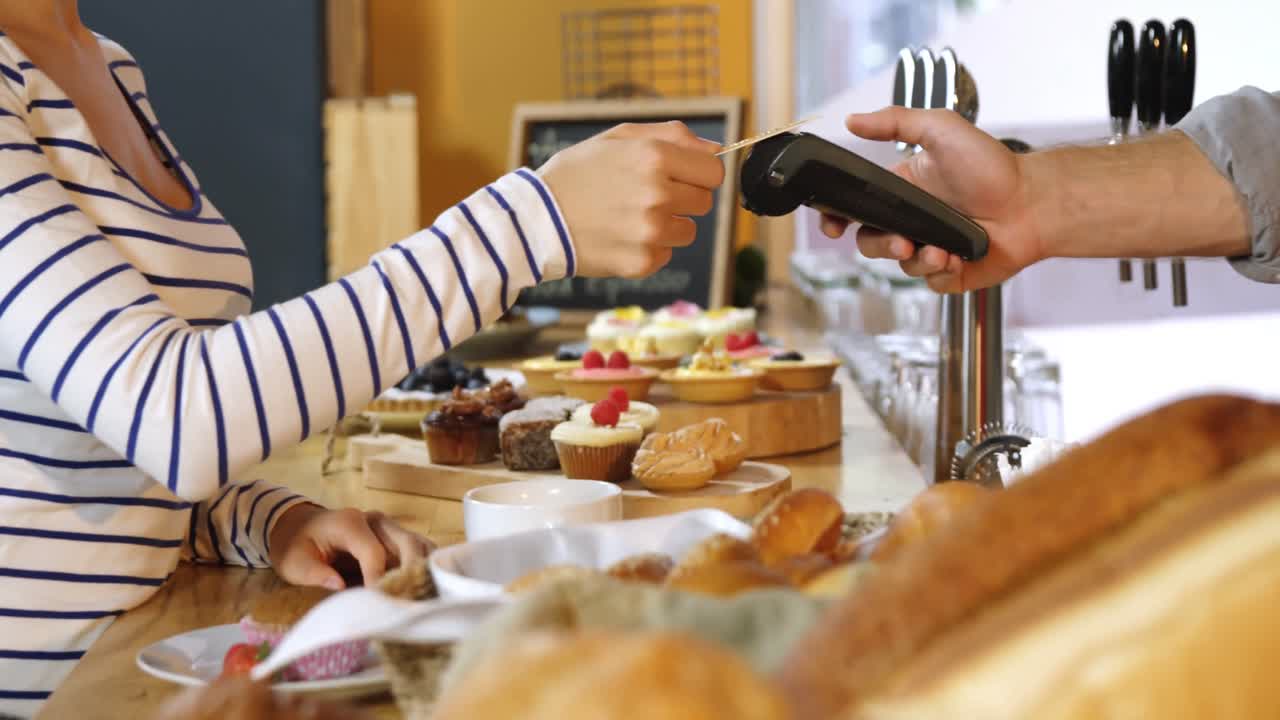 cliente femenino que realiza un pago a través de una tarjeta de débito 4k