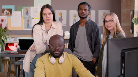 multiethnic team of graphic designers smiling at camera in an animation studio 2