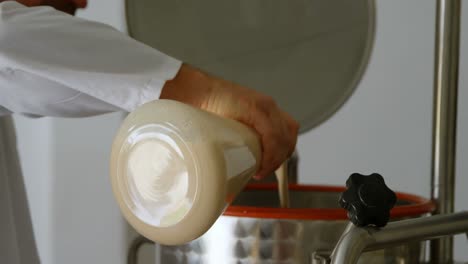 male worker pouring liquor in distillation tank 4k