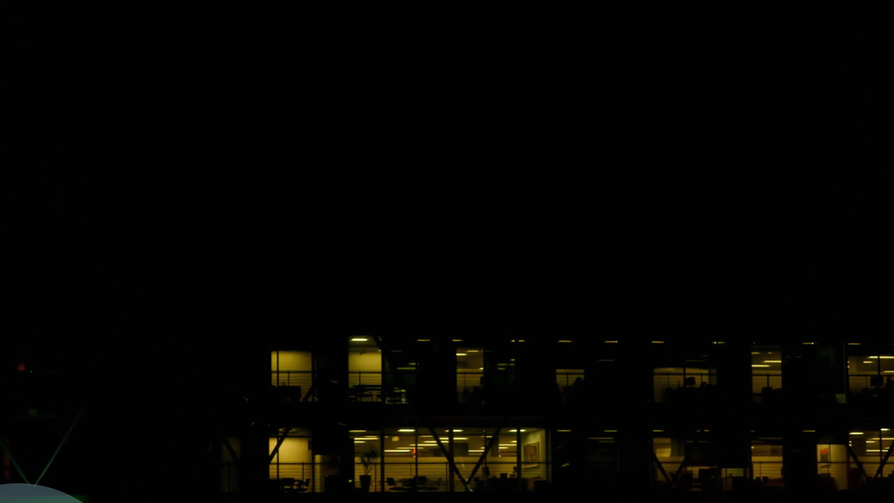 animación de múltiples iconos gráficos sobre vista aérea de un edificio moderno contra el cielo nocturno