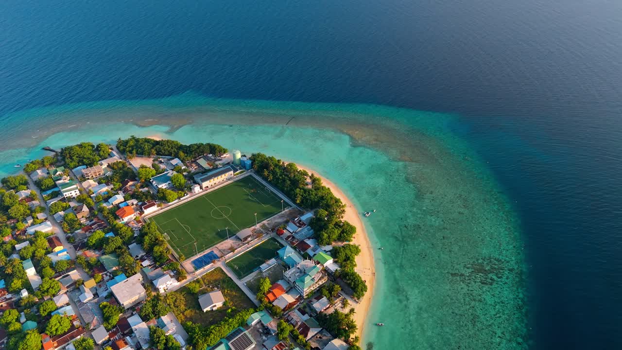 A breathtaking aerial drone view captures Rasdhoo Island bathed in the warm glow of sunset in the Maldives.
