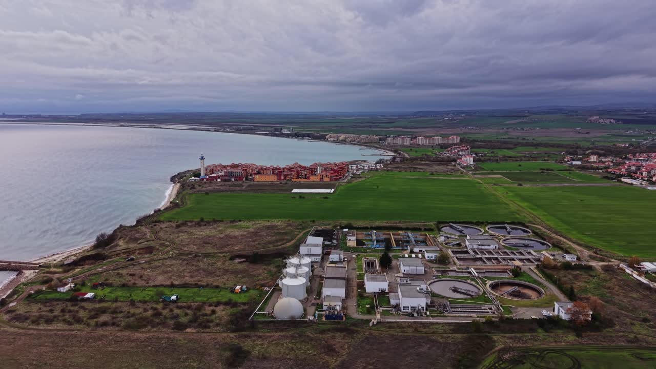 Coastal landscape with water treatment facility near a serene shoreline