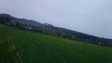 A-zoom-in-shot-of-a-passenger-train-passing-through-green-filed