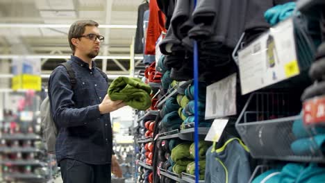 hombre comprando ropa en una tienda de artículos deportivos