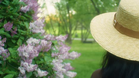 mujer negra caminando oliendo flores lilas amplio pan cerrar