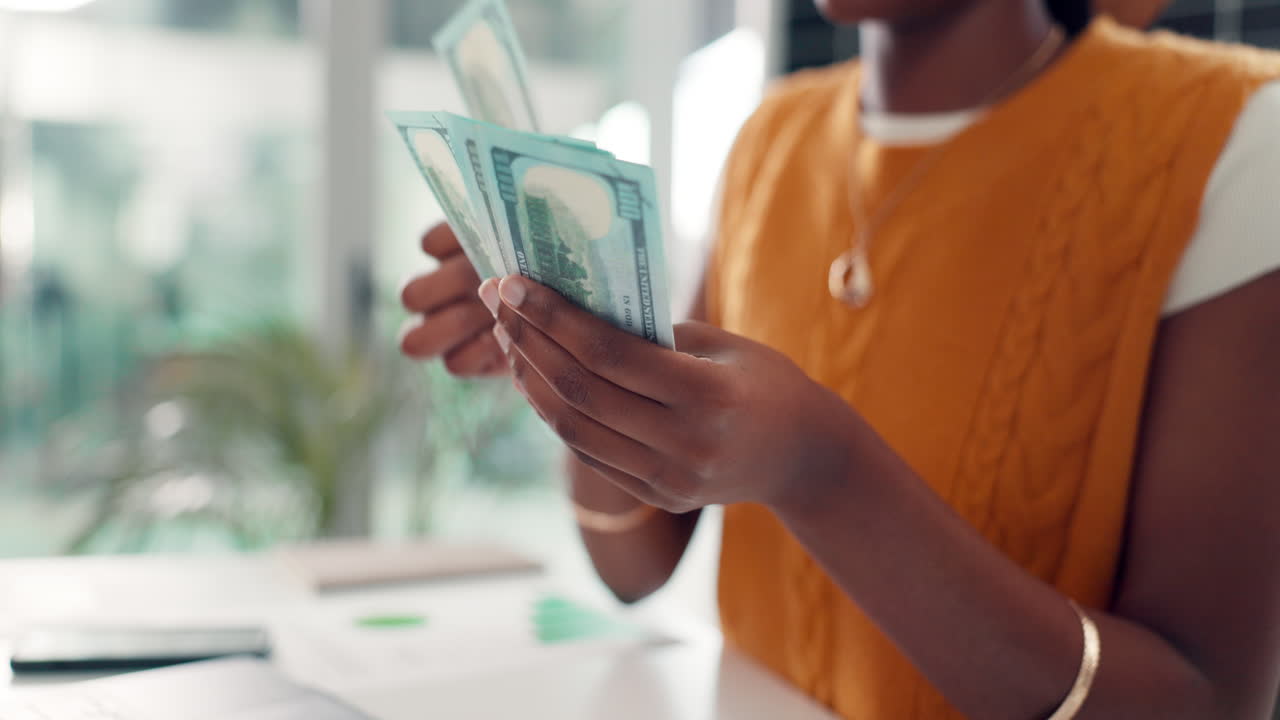 Primo piano di mani che contano banconote da cento dollari