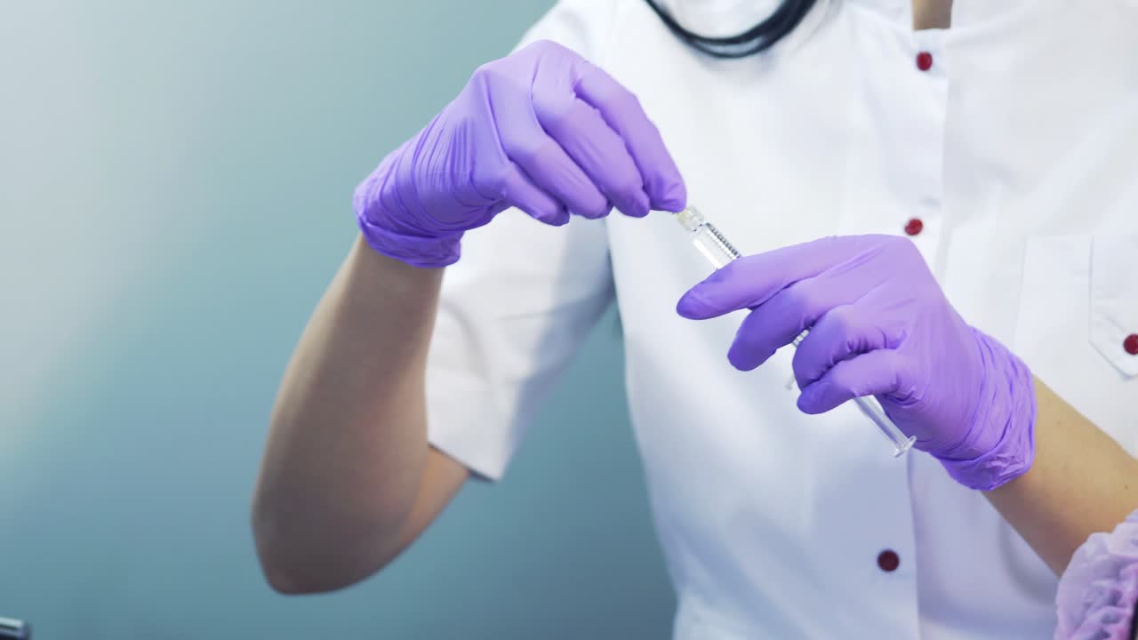 Syringe with a needle with an injection of beauty. Cosmetologist is putting a needle on a syringe.
