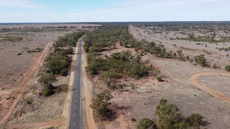 Drone-descending-over-a-country-road,-fuel-tanker-passing-by