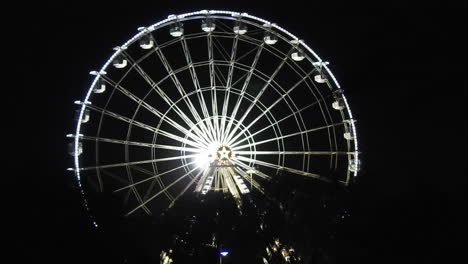 Vista-Nocturna-Del-Parque-De-Atracciones-Por-La-Noche,-Gran-Noria-Con-Iluminación-Azul-Festiva-Contra-El-Cielo-Nocturno,-Famosa-Atracción-Turística,-Ciudad-De-Agadir-En-Marruecos