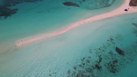 aerial top view coral reef tilt up reveal tropical sandbank waves crash on sand, los roques