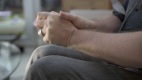hombre preocupado, ansioso y estresado sentado frotándose las manos con desesperación