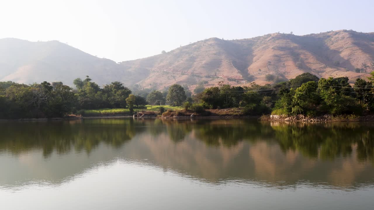 lago prístino aislado con reflejo de agua por la mañana desde un ángulo plano