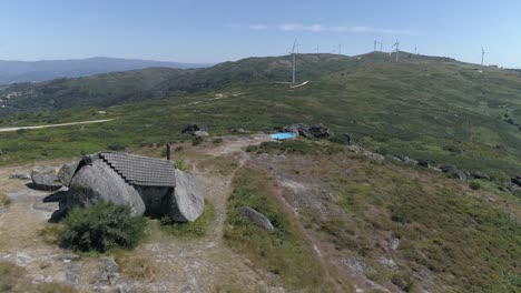 Luftaufnahme-Eines-Hauses-In-Den-Bergen-Mit-Windmühlen