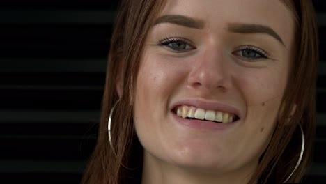 Close-up-shot-of-a-young-woman-with-brown-hair-as-she-looks-directly-at-the-camera-and-smiles-and-laughs