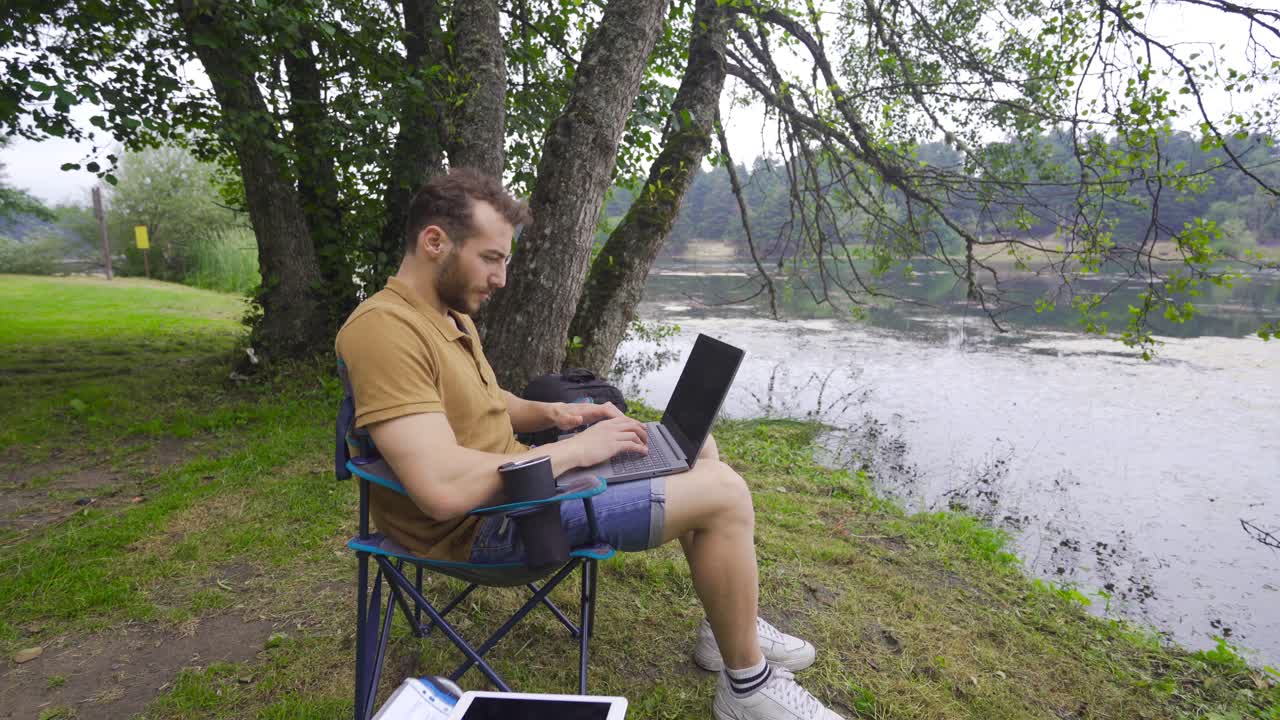 trabajando con la computadora junto al lago.