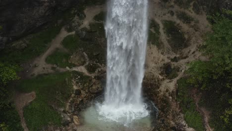 Base-of-Wildenstein-Waterfall-in-the-southern-Austrian-Alps-with-eroded-rock,-Aerial-pedestal-down-reveal-shot