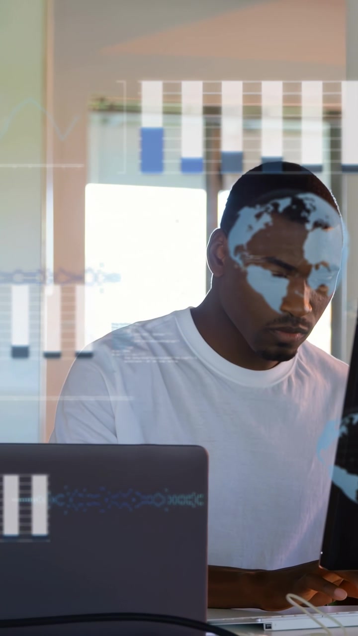Vertical video: Man at desk typing, causing tech overlays of charts map code for data analysis