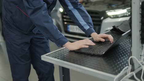 mechanic working on a car with a laptop