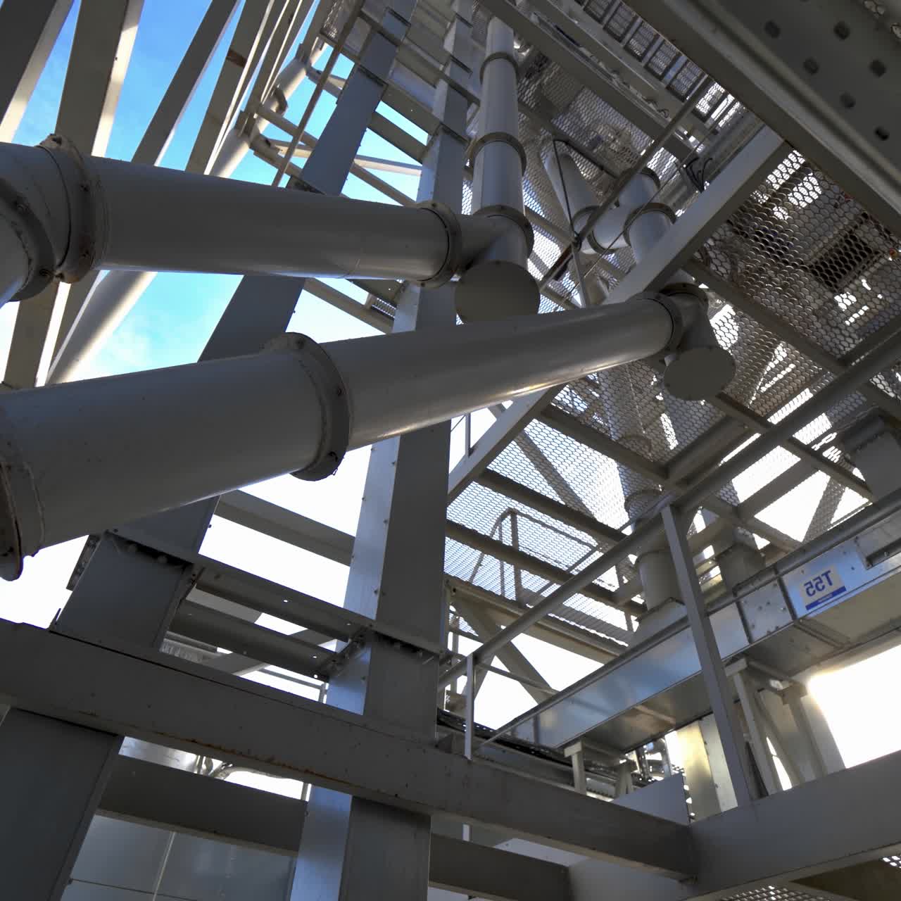 Industrial plant with pipes. Metal structure on a modern granary. Steel frame construction against the sunlight. Modern storehouse.