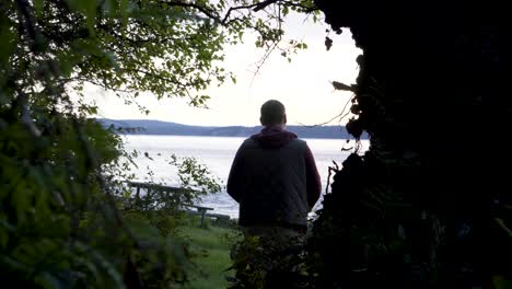 POV-Of-A-Person-Walking-Through-Lush-Foliage-Following-A-Man-With-Dog-At-Washington-Park-In-Anacortes,-Washington-USA