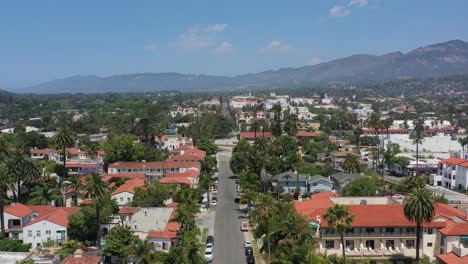 wide-aerial-view-of-a-commercial-street-in-downtown-Santa-Barbara-California-on-a-sunny-summer-day-with-no-traffic-and-dry-rugged-mountains-in-the-distance