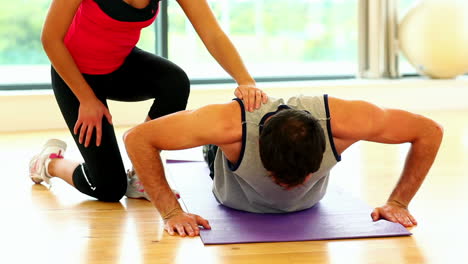 Fit-toned-man-doing-pressups-in-fitness-hall