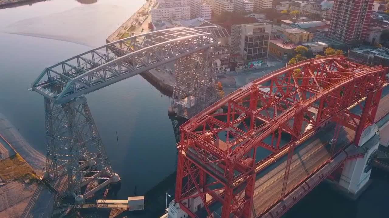 Puente de la Boca (Boca Bridge), in Buenos Aires. Flying on top revealing the river beneath. Some sunflares visible.