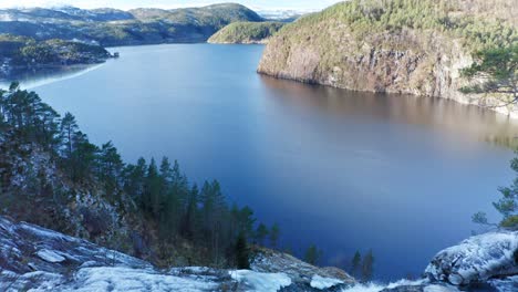 Hombre-De-Pie-En-El-Borde-De-Las-Impresionantes-Cascadas-Hesjedalsfossen---Stamnes-Noruega-Congeladas