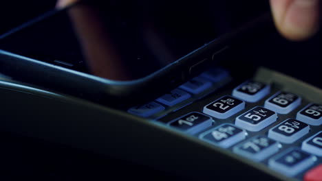 Mobile-NFC-Zahlung.-Hand-Des-Kunden,-Der-Mit-Mobiltelefon-Im-POS-Terminal-Bezahlt