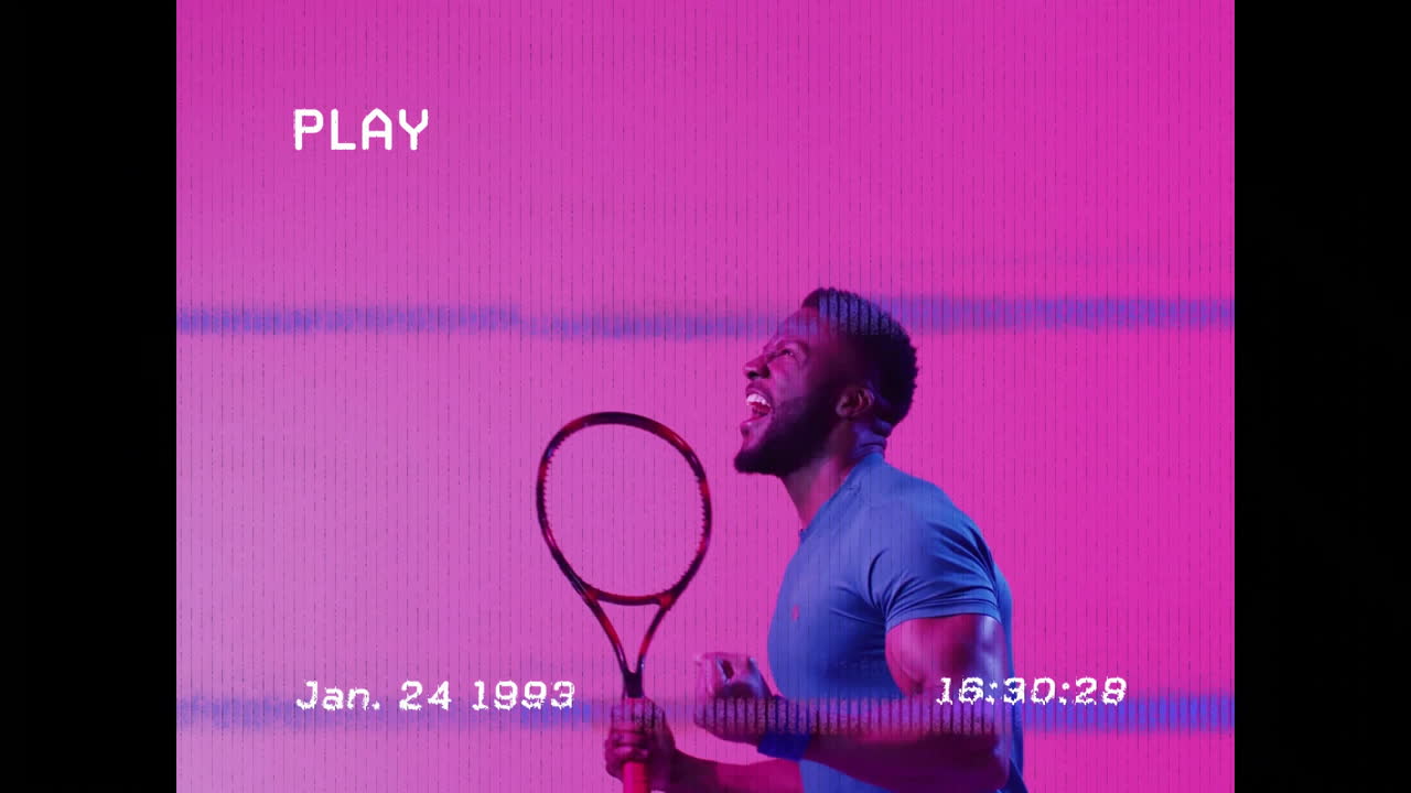 Holding tennis racket, man celebrating passionately against vibrant pink background