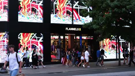 pedestrians walking past a vibrant storefront