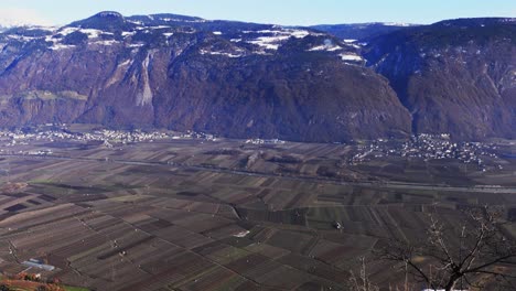 View-over-orchards-in-winter-in-the-Adige-Valley-towards-the-Tschögglberg-mountain,-Burgstall-and-Gargazon,-South-Tyrol,-Italy