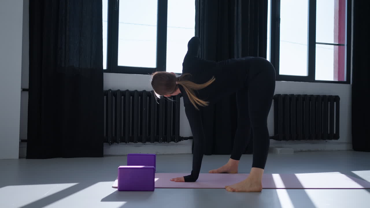 mujer haciendo postura de yoga en un estudio