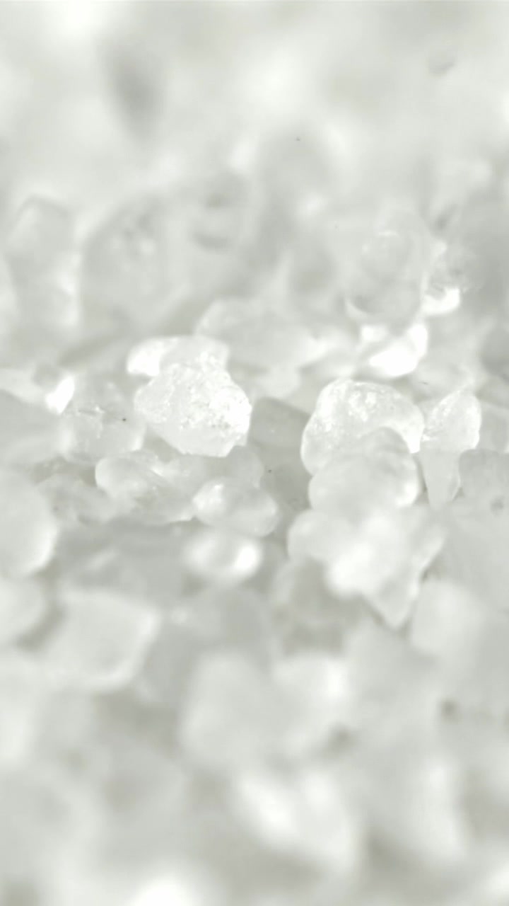 Macro ripresa al rallentatore di cristalli di sale bianco in caduta