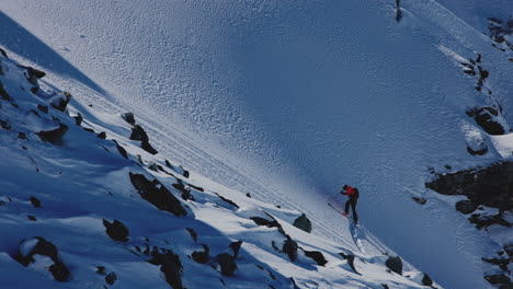 a professional skier hikes up a steep ridge in verbier, then drops into an epic freeride descent. pure adventure skiing in deep snow, dramatic terrain, and breathtaking alpine scenery.