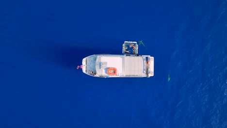sharks swim around a tour boat with a cage in the blue ocean off oahu, hawaii