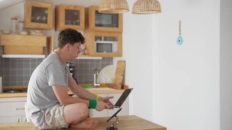 hombre trabajando en una computadora portátil en una cocina