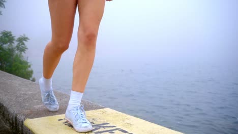 female legs on beach sea. woman feet walking on border sea