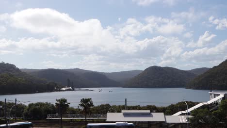 Timelapse-De-Hermosas-Montañas-Y-Lago-Con-Estación-De-Tren-Y-Carretera-De-Una-Pequeña-Ciudad,-Woy-Woy-Nsw