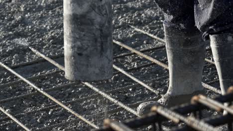 workers apply a layer of cement to create the floor and roof of a large area under construction