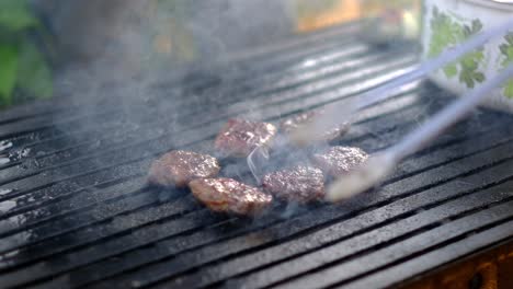 cooked meatballs are taken and turned with tongs slow motion