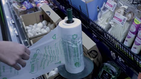 person bags mushrooms at a grocery store