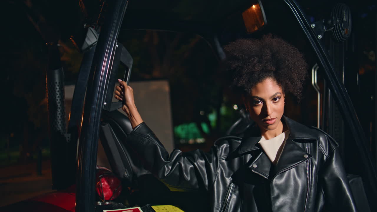 Confident lady looking camera standing near forklift late night closeup