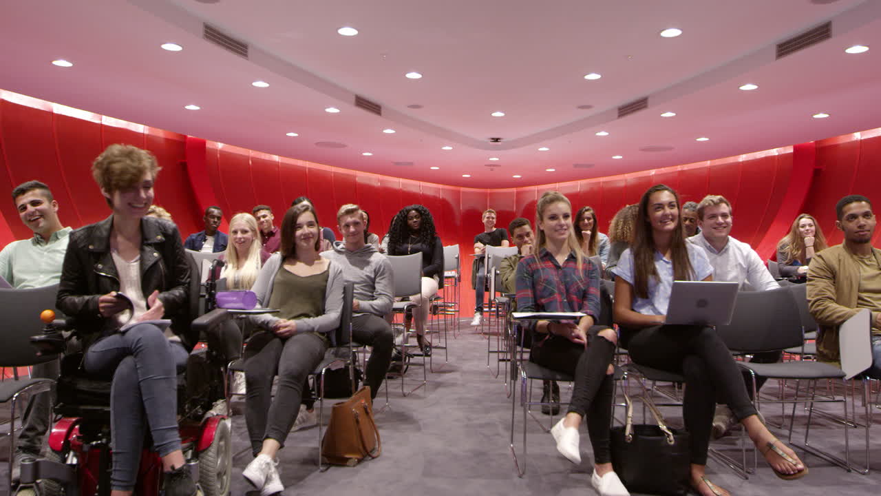 los estudiantes se sientan frente a la cámara en un aula universitaria moderna, filmado en r3d