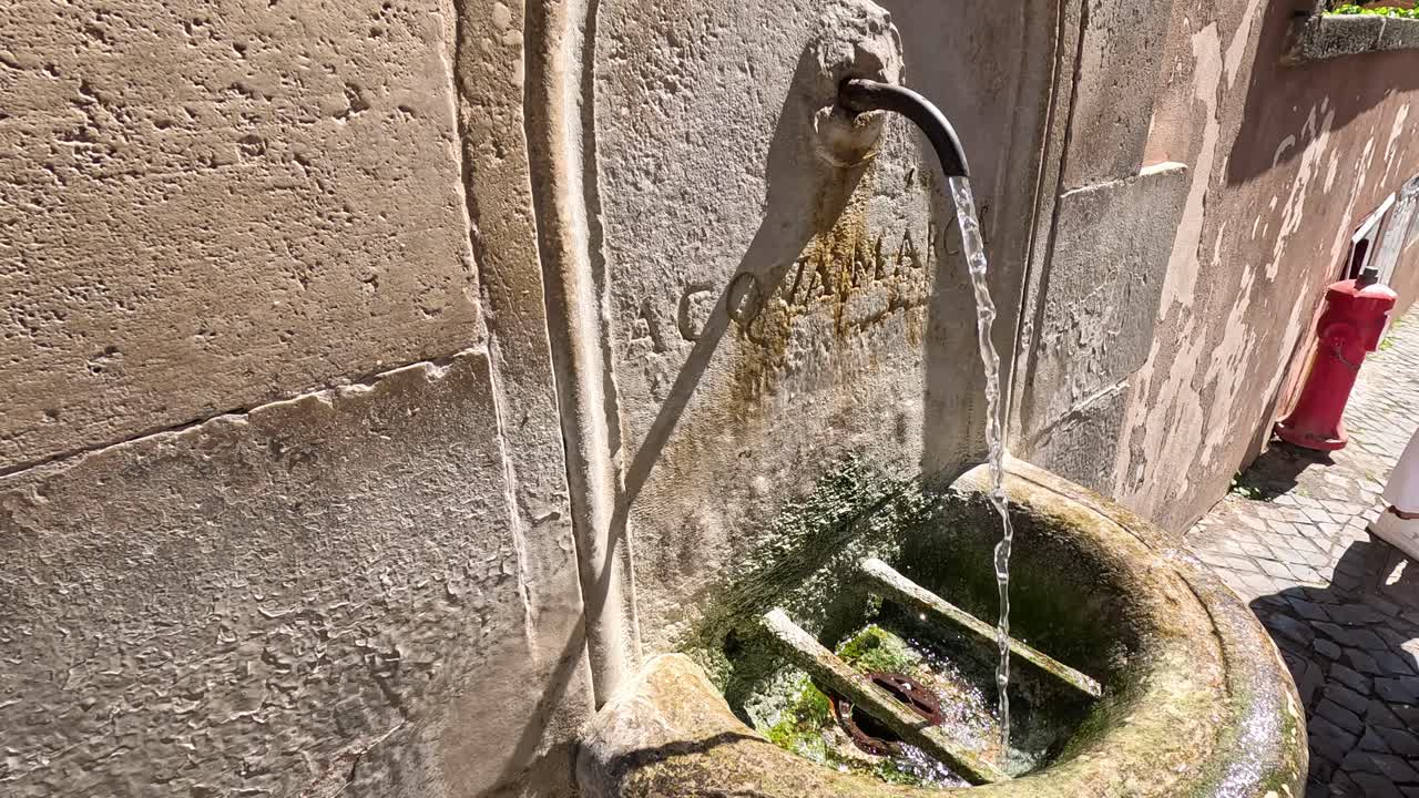 corrientes de agua de una fuente de piedra cubierta de musgo