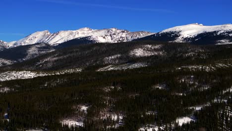 colorado rocky mountain national park fraser corona pass winter park ski resort mountain town aerial drone berthoud pass winter december snow blue sky sunny blanket of snow upwards jib motion