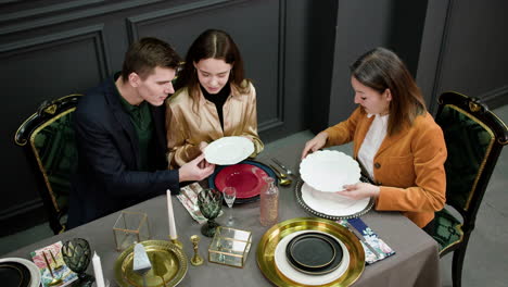 asian woman talking with a couple sitting at a table